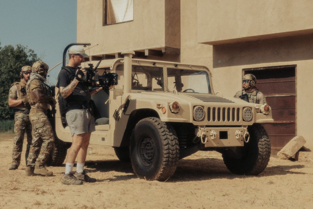 2 boys standing beside brown jeep wrangler